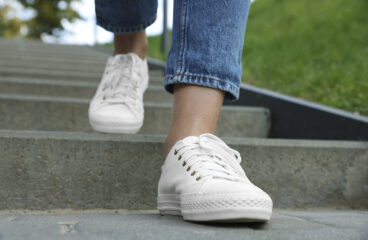 Woman In Stylish Black Sneakers Walking Down Stairs, Closeup