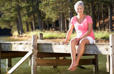 Senior Woman Sitting By Lake